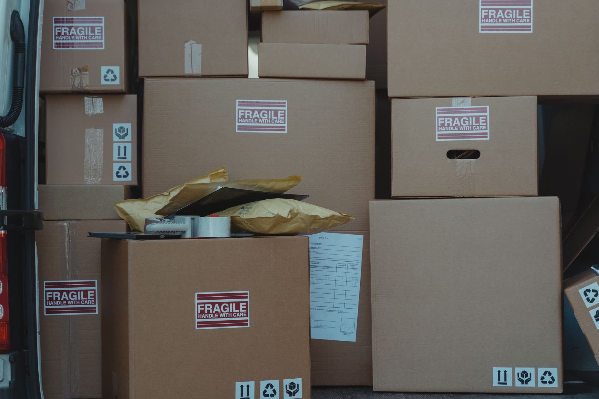 Sealed shipping cartons with fragile labels and a packing list, stacked ready for dispatch.