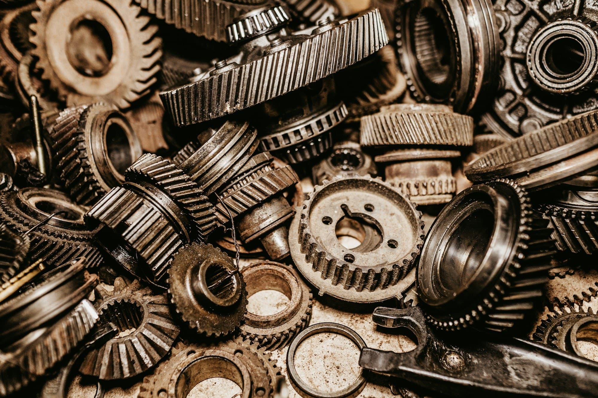 Close-up of heavy steel gears, bearings and transmission components piled together.