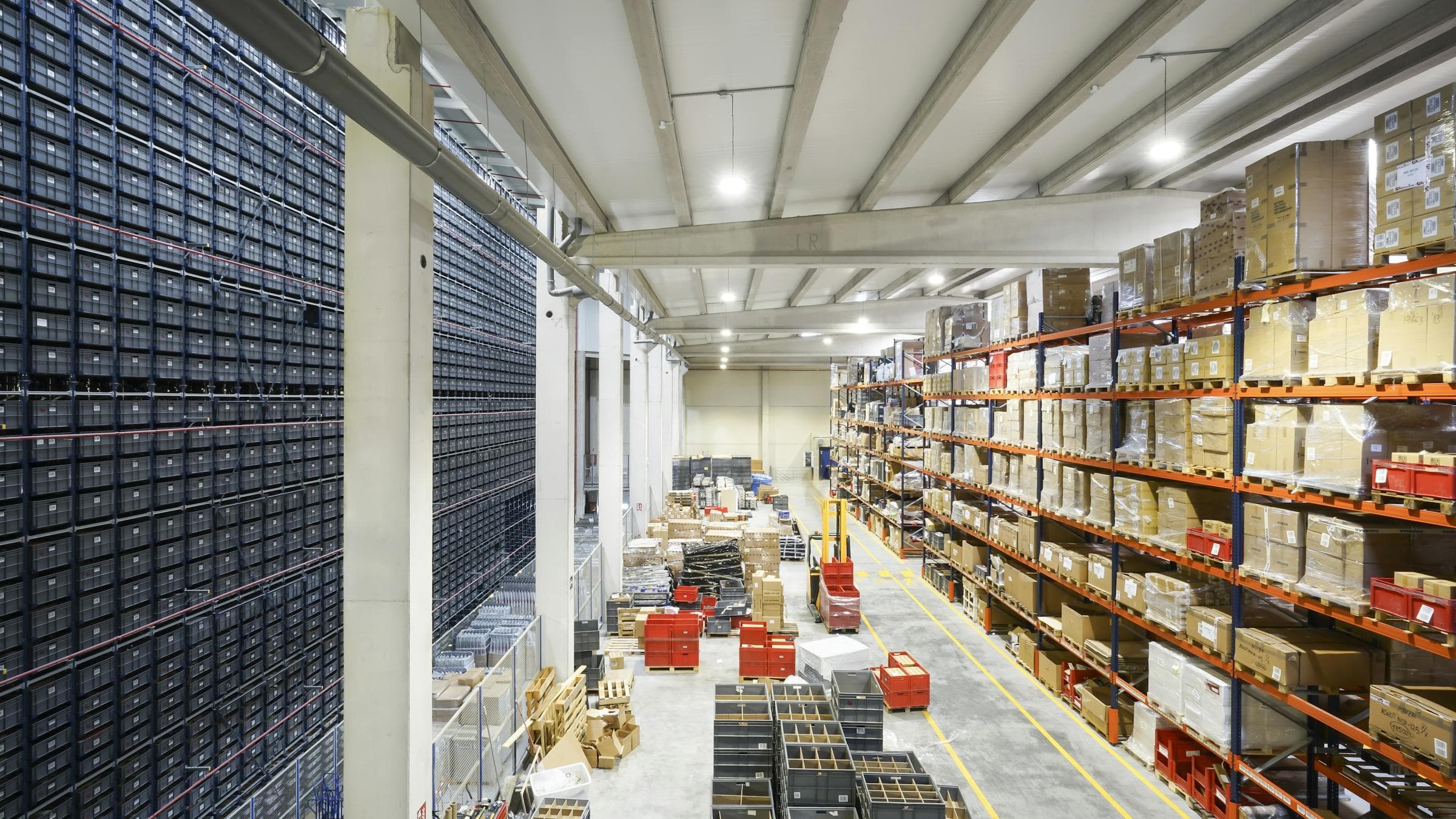 A parts warehouse with loaded pallet racking along the aisles.